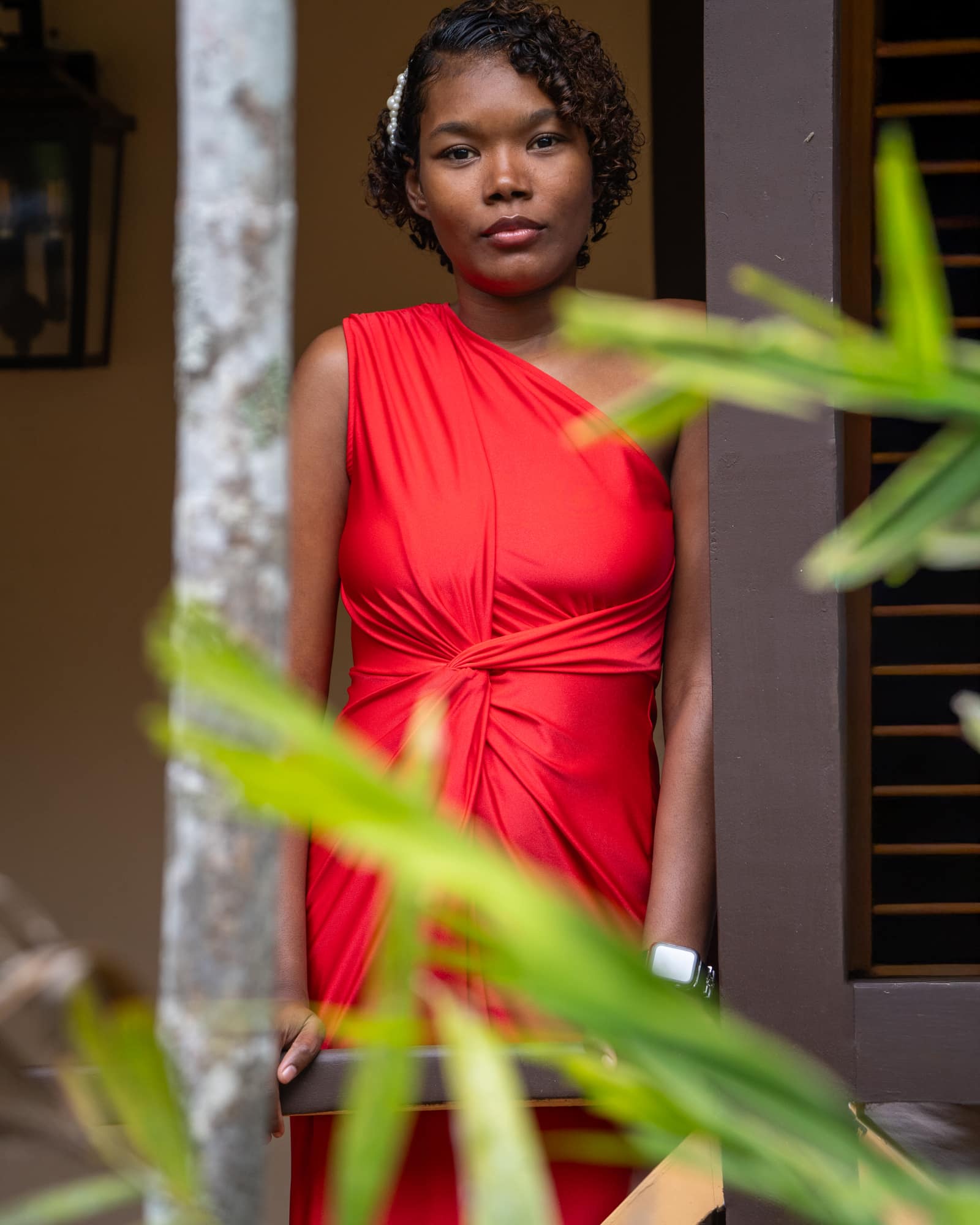 Stevie-Ann in her red dress by the shuttered windows